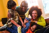 Family playing on a sofa.