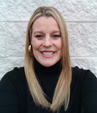 A photo of State Support Team Region 7 consultant Olivia Siegfried.  She is a Caucasian woman who with long, straight blonde hair.  She is wearing a black turtleneck and gold hoop earrings while standing in front of a white background.